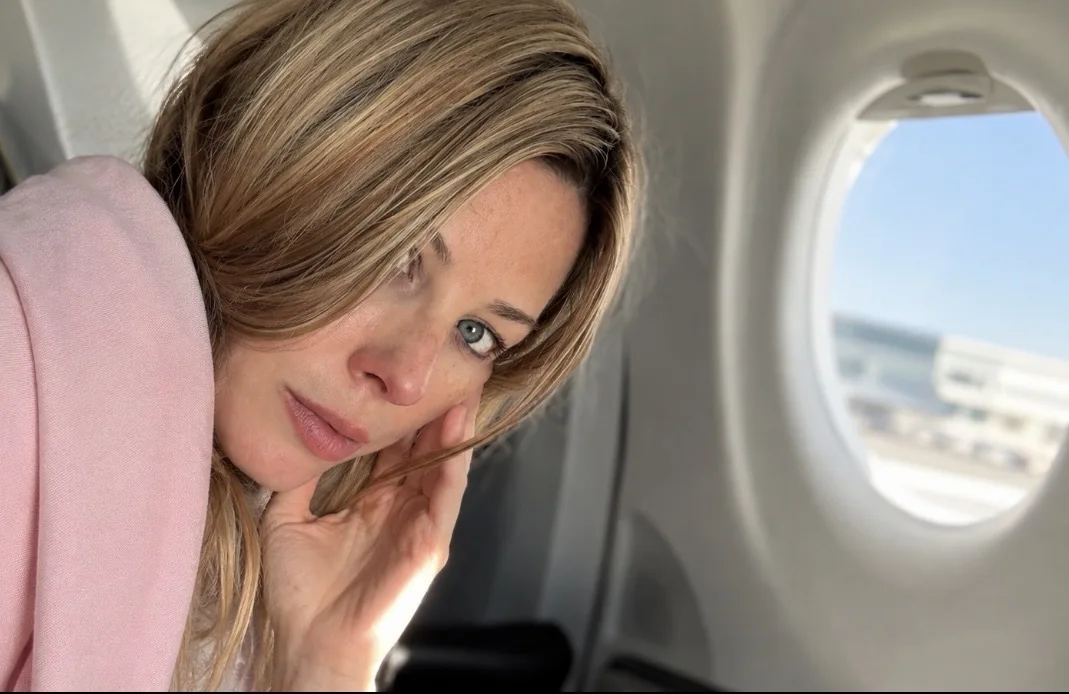 Jennifer seated by an airplane window